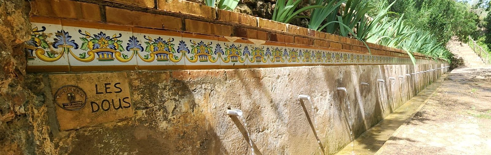 El mur de rajoles amb els 35 sortidors de Les Dous